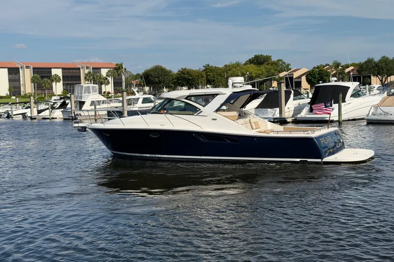 Slide: The Image of 2013 Tiara Yachts 3600 Coronet cruising in a marina, surrounded by other boats. - 1