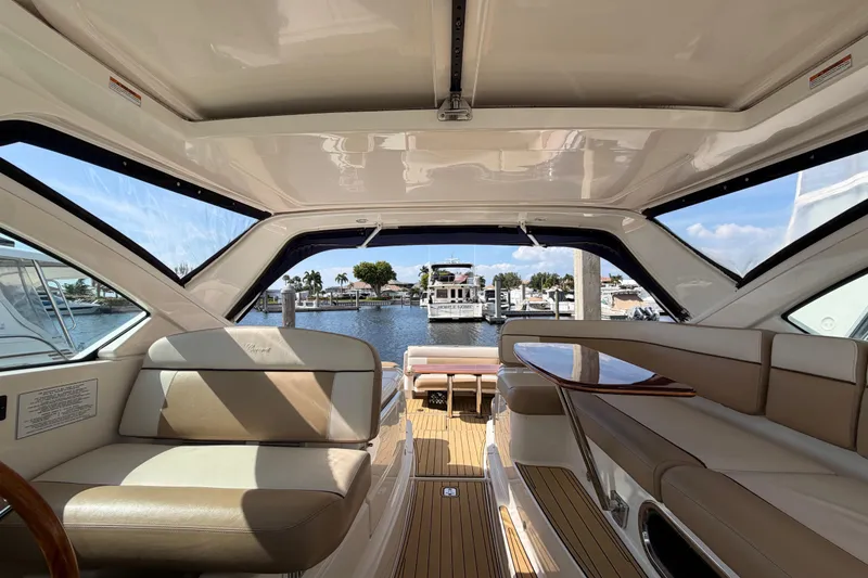Slide: The Image of Interior view of 2013 Tiara Yachts 3600 Coronet, featuring luxurious seating and marina backdrop. - 10