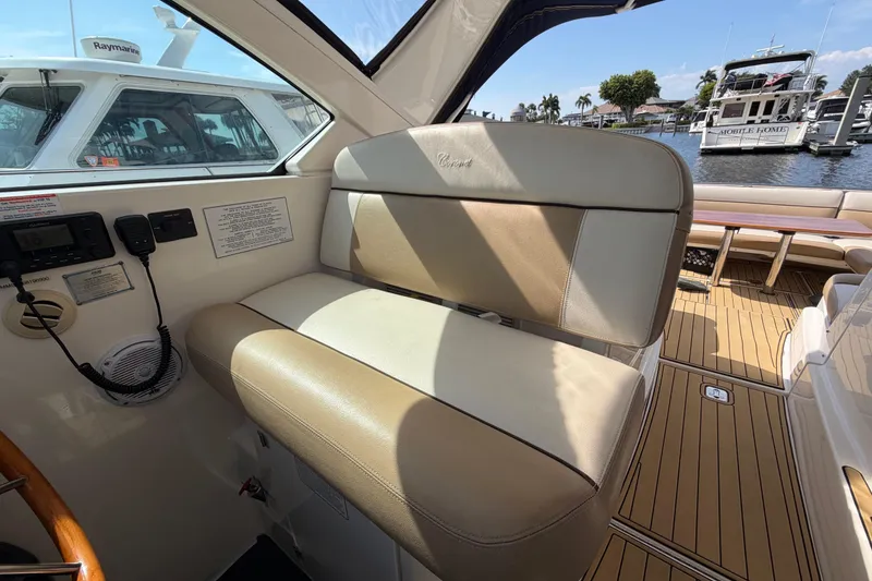 Slide: The Image of Interior of 2013 Tiara Yachts 3600 Coronet, featuring beige seating and control panel. - 15