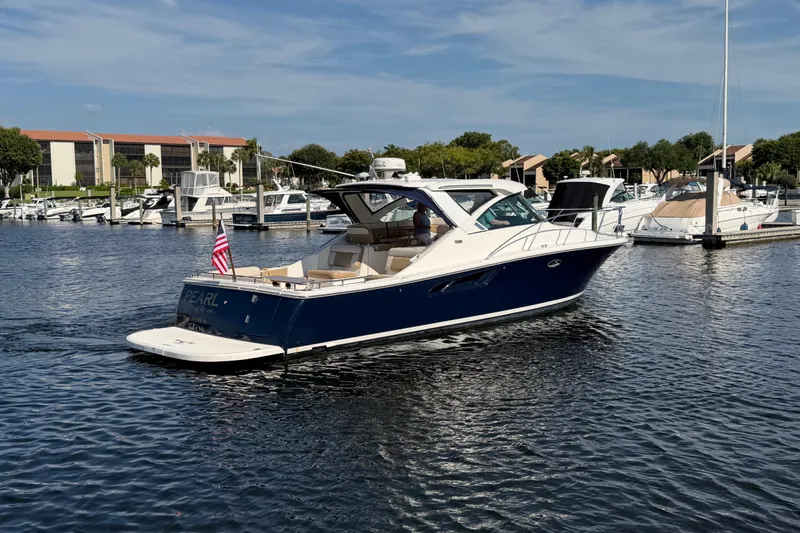Slide: The Image of 2013 Tiara Yachts 3600 Coronet cruising in a marina under a clear blue sky. - 2