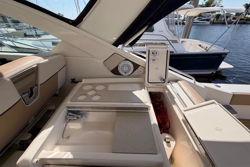 Slide: The Image of 2013 Tiara Yachts 3600 Coronet interior with seating and storage, docked by the water. - 24