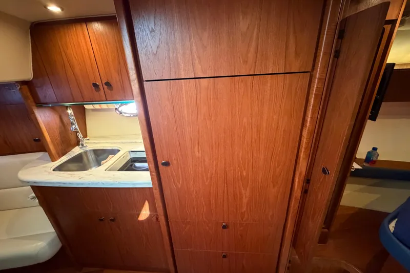 Slide: The Image of 2013 Tiara Yachts 3600 Coronet interior with wooden cabinetry and compact kitchen area. - 32