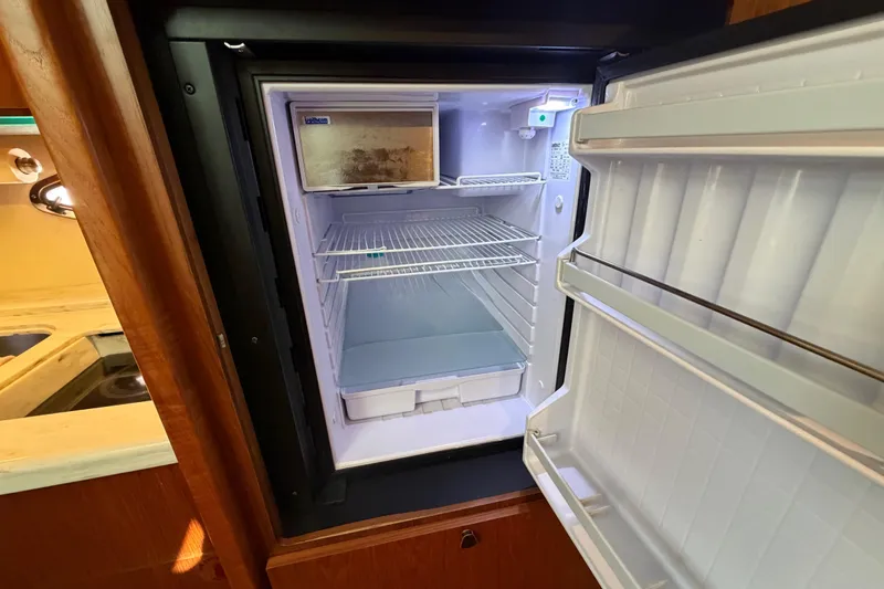 Slide: The Image of Open refrigerator inside 2013 Tiara Yachts 3600 Coronet, showcasing interior shelves and storage. - 33