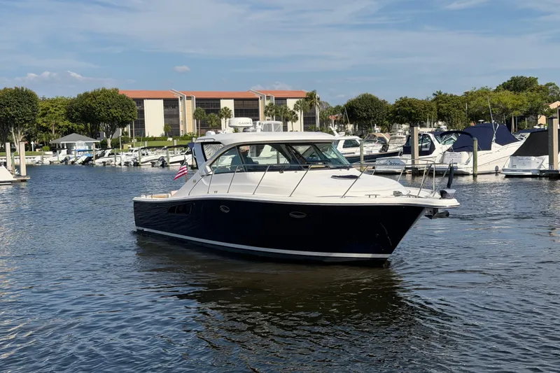 Slide: The Image of 2013 Tiara Yachts 3600 Coronet in marina, surrounded by boats and waterfront buildings. - 4
