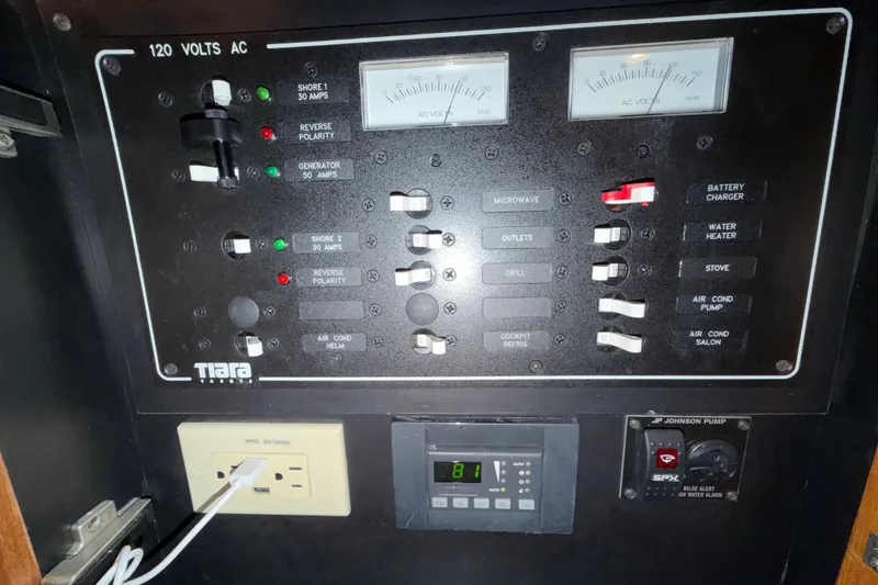 Slide: The Image of Electrical control panel of a 2013 Tiara Yachts 3600 Coronet, featuring various switches and meters. - 43