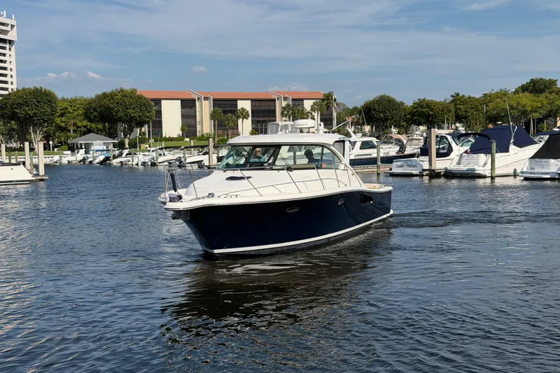 Slide: The Image of 2013 Tiara Yachts 3600 Coronet cruising in a marina under a clear blue sky. - 5