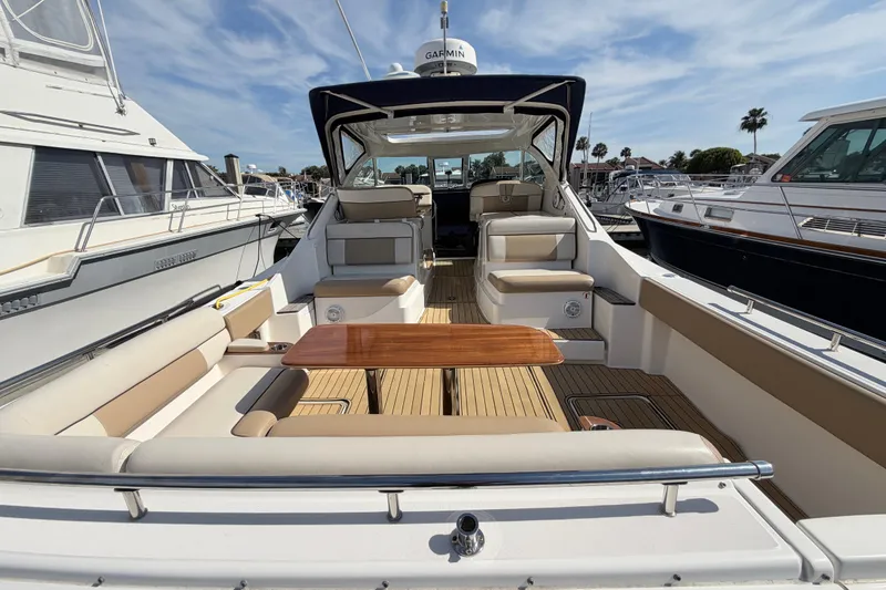 Slide: The Image of 2013 Tiara Yachts 3600 Coronet with spacious deck and seating at marina. - 8