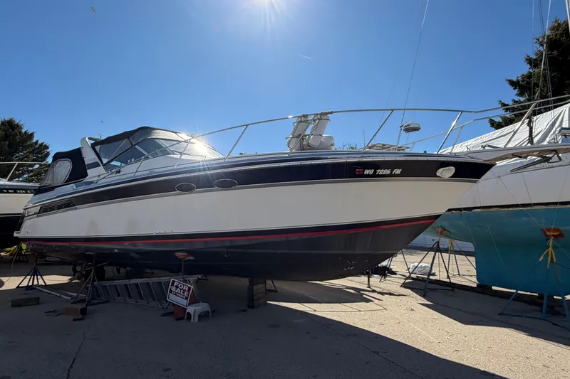 The Image of 1989 Wellcraft 3400 Gran Sport boat on display, sunny day, "For Sale" sign visible. - 0