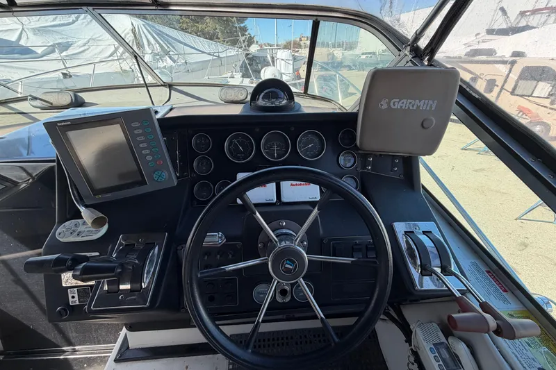 Slide: The Image of Cockpit of 1989 Wellcraft 3400 Gran Sport with steering wheel and navigation equipment. - 13