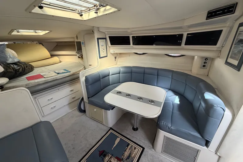 Slide: The Image of 1989 Wellcraft 3400 Gran Sport interior with blue seating, table, and skylight. - 18