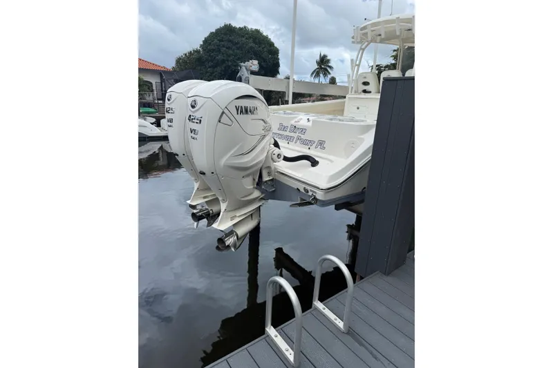 Slide: The Image of 2020 Cobia 350 Center Console with twin Yamaha 425 engines docked by water. - 3