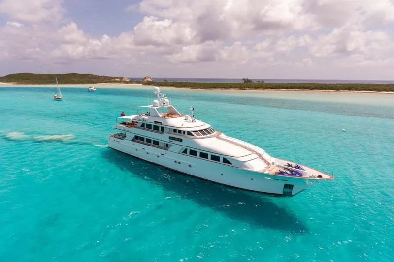 The Image of Luxurious 1997 Palmer Johnson Semi-Displacement yacht cruising in turquoise waters near a sandy island. - 1
