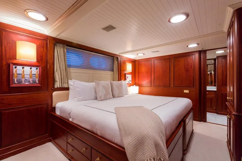Slide: The Image of Luxurious Palmer Johnson 1997 yacht bedroom with elegant wood paneling and cozy bedding. - 13