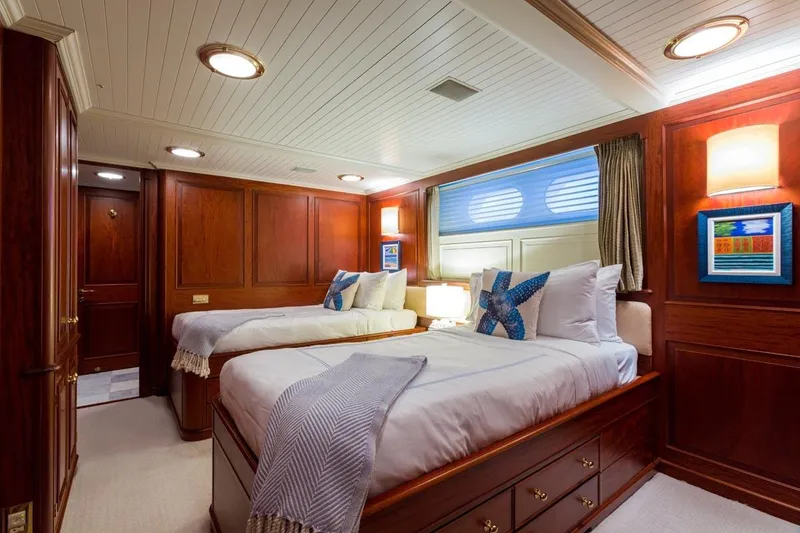 Slide: The Image of Luxurious twin cabin interior on a 1997 Palmer Johnson Semi-Displacement yacht, featuring elegant wood paneling. - 14
