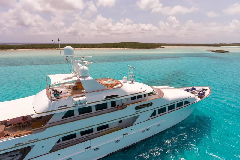 Slide: The Image of Luxurious 1997 Palmer Johnson Semi-Displacement yacht cruising in turquoise waters near a sandy beach. - 22