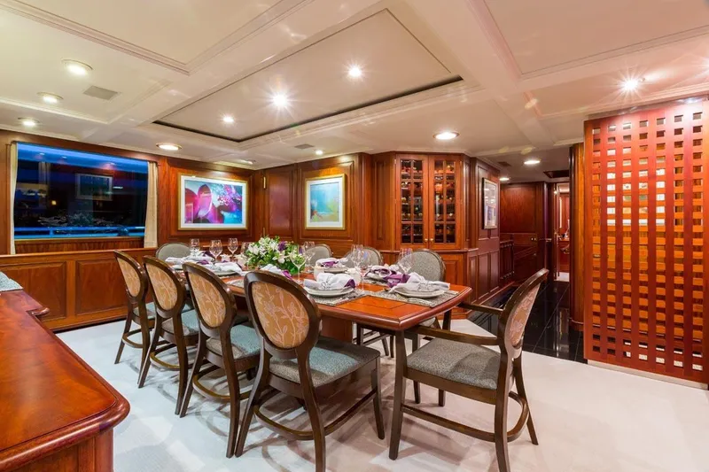 Slide: The Image of Luxurious dining area on a 1997 Palmer Johnson Semi-Displacement yacht, featuring elegant wood finishes. - 4