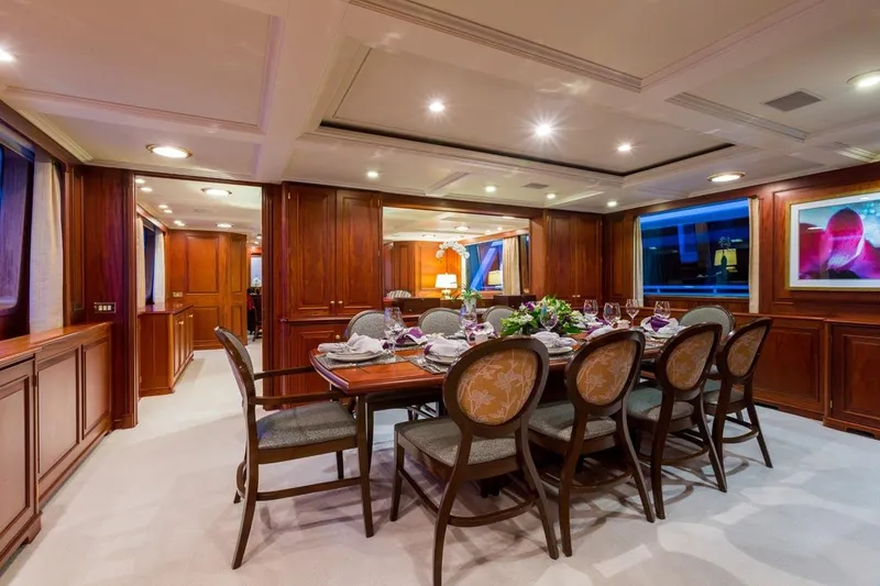 Slide: The Image of Luxurious dining area on a 1997 Palmer Johnson Semi-Displacement yacht, featuring elegant wood paneling. - 5