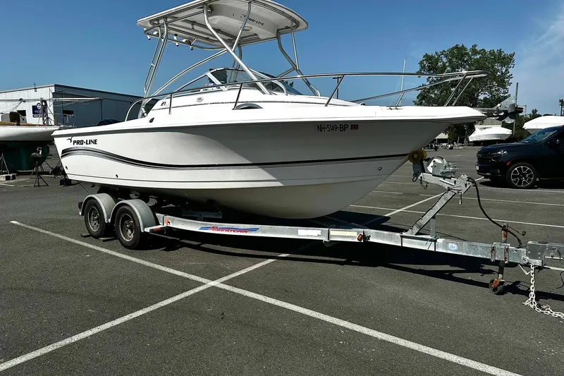 Slide: The Image of 2006 Pro-Line 21 Walkaround boat on trailer in parking lot, sunny day. - 11
