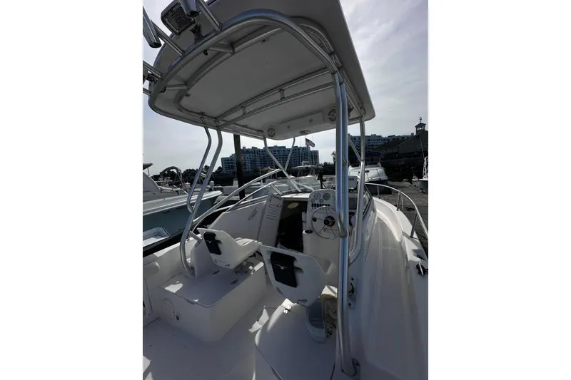 Slide: The Image of 2006 Pro-Line 21 Walkaround boat interior with steering console and seating at marina. - 4
