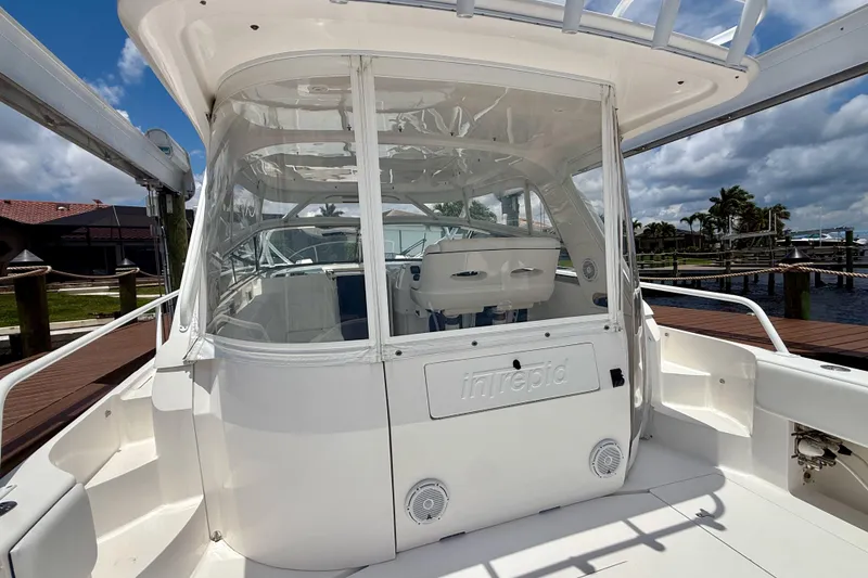 Slide: The Image of 2013 Intrepid 430 Sport Yacht docked, showcasing sleek design and spacious cockpit area. - 13