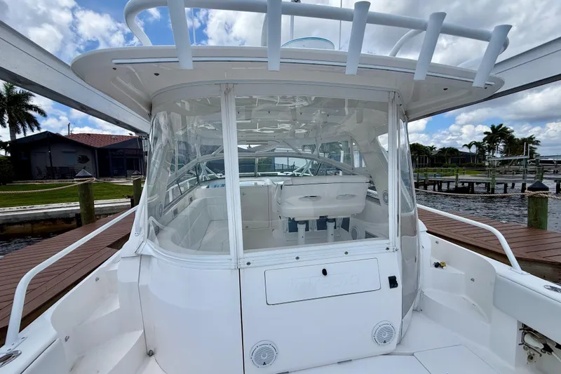 Slide: The Image of 2013 Intrepid 430 Sport Yacht docked, showcasing sleek design and spacious cockpit. - 16
