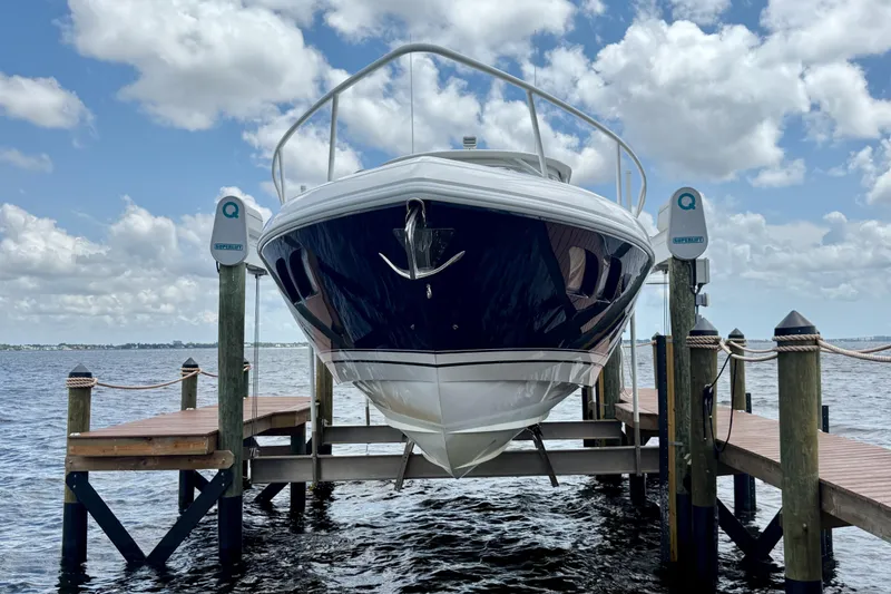 Slide: The Image of Intrepid 430 Sport Yacht 2013 on lift, docked by the water under a cloudy sky. - 2