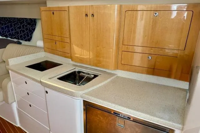 Slide: The Image of Modern kitchen area in a 2013 Intrepid 430 Sport Yacht with wooden cabinets. - 38