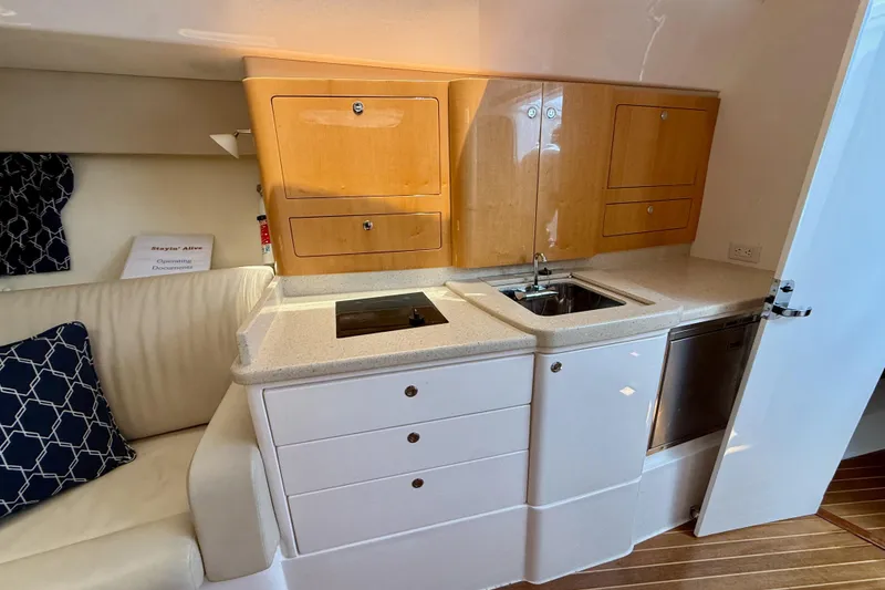 Slide: The Image of Compact kitchen area in a 2013 Intrepid 430 Sport Yacht with wooden cabinets and modern appliances. - 39