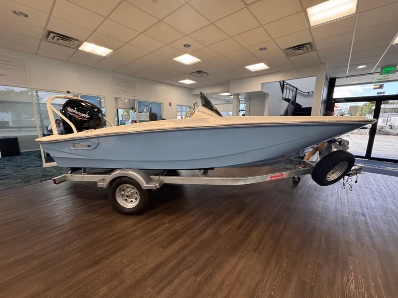 Slide: The Image of A 2027 Boston Whaler 160 Super Sport on a trailer in a showroom setting. - 0