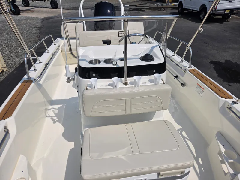 Slide: The Image of The image shows the cockpit of a 2027 Boston Whaler 170 Montauk with white upholstery and stainless steel railings. - 17