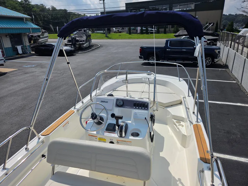 Slide: The Image of The image shows a Boston Whaler 170 Montauk boat with a blue sunshade and modern helm. - 29