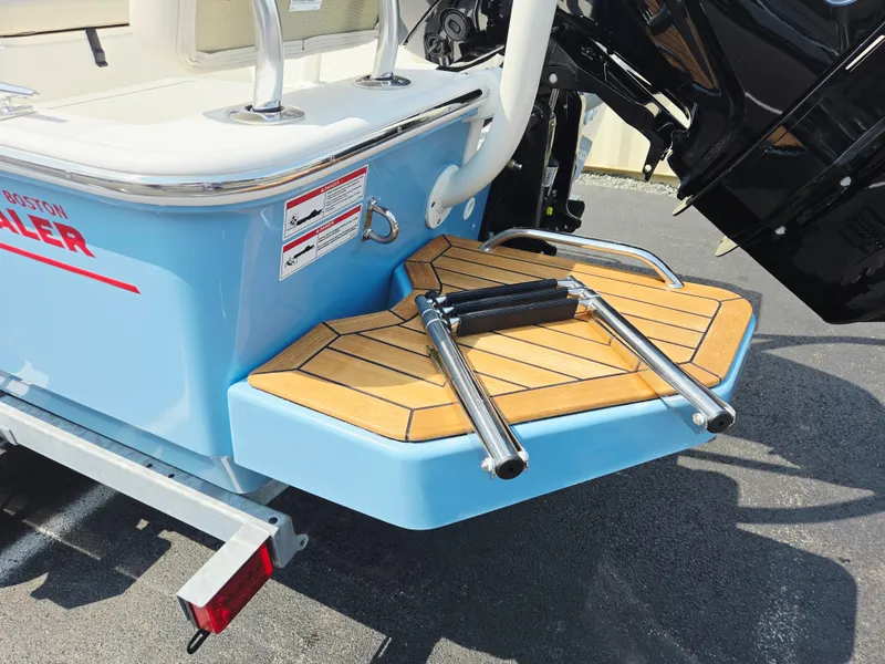 Slide: The Image of The image shows the stern of a Boston Whaler 170 Montauk with a blue swim platform and ladder. - 11