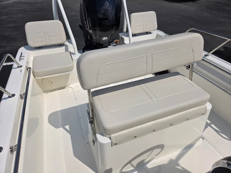 Slide: The Image of The image shows the cockpit of a Boston Whaler 170 Montauk with beige upholstery and an outboard motor. - 23