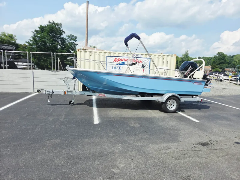Slide: The Image of A blue 2027 Boston Whaler 170 Montauk sits on a trailer in a parking lot. - 1
