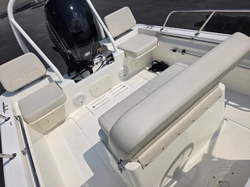 Slide: The Image of The image shows the cockpit of a 2027 Boston Whaler 170 Montauk with white upholstery and an outboard motor. - 25