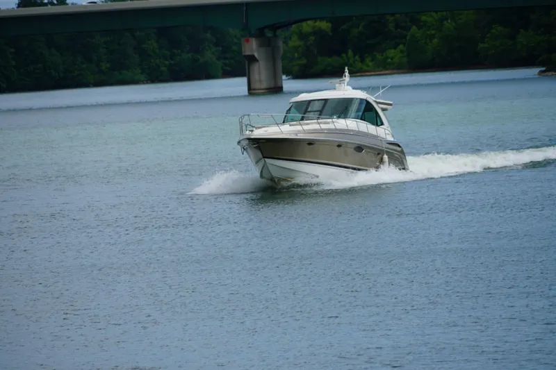 Slide: The Image of 2016 Formula 45 Yacht cruising on a serene river under a bridge. - 2