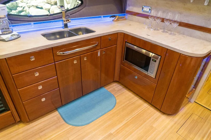 Slide: The Image of Luxurious kitchen area in a 2016 Formula 45 Yacht with wood cabinetry and modern appliances. - 48
