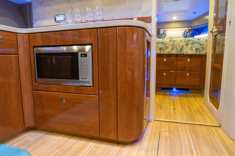 Slide: The Image of Interior of 2016 Formula 45 Yacht featuring a modern kitchen with microwave and elegant wood finish. - 49
