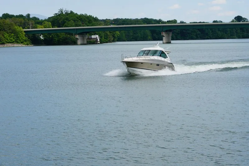 Slide: The Image of 2016 Formula 45 Yacht cruising on a serene river near a green bridge. - 5