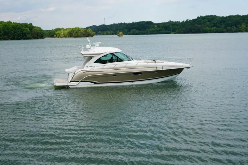 Slide: The Image of 2016 Formula 45 Yacht cruising on a serene lake with lush green surroundings. - 7