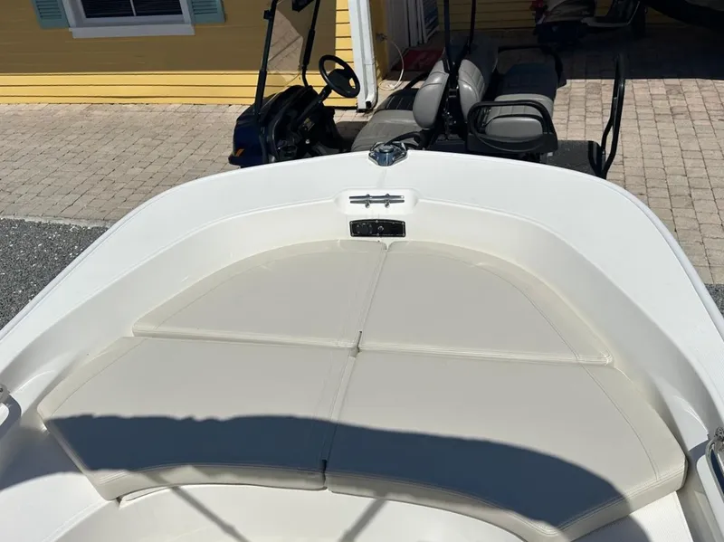 Slide: The Image of The boat features a cushioned bow deck and is parked in front of a yellow building. - 6