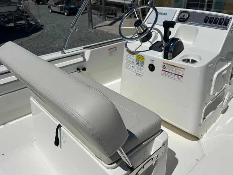Slide: The Image of The image shows the cockpit of a Boston Whaler 170 Montauk with a helm and bench seat. - 13
