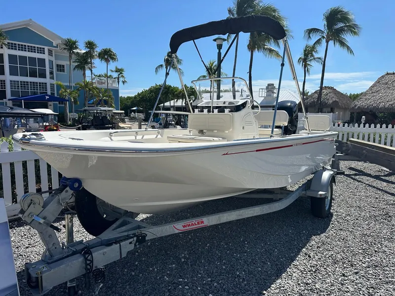 Slide: The Image of Boston Whaler 170 Montauk 2027 on a trailer, surrounded by palm trees and buildings. - 2