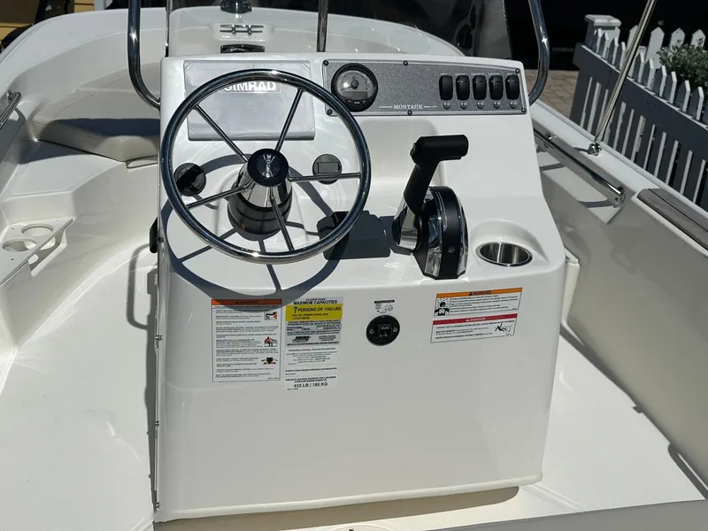 Slide: The Image of The image shows the helm of a Boston Whaler 170 Montauk with a steering wheel and throttle. - 10
