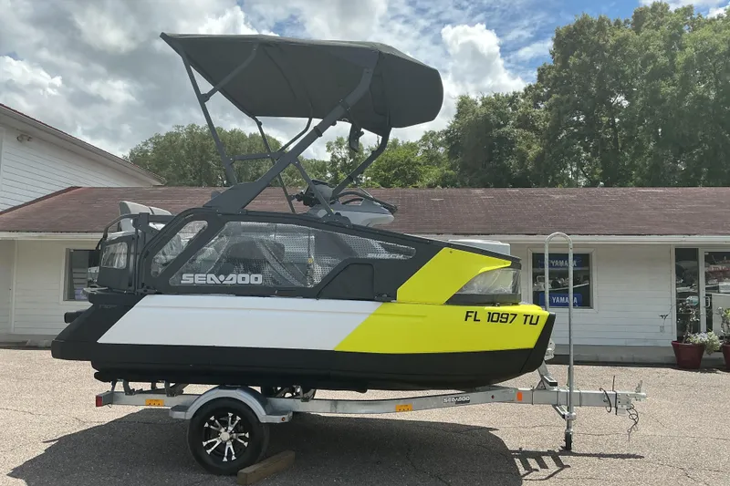 Slide: The Image of 2023 Sea-Doo Switch Sport Compact on trailer, parked outside a building under a cloudy sky. - 17