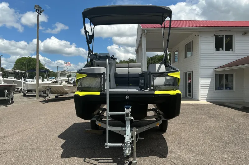 Slide: The Image of 2023 Sea-Doo Switch Sport Compact boat on trailer at dealership, under cloudy sky. - 19