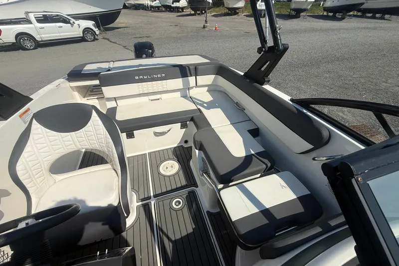 Slide: The Image of 2019 Bayliner VR5 Bowrider OB interior with seating and steering wheel, parked outdoors. - 13