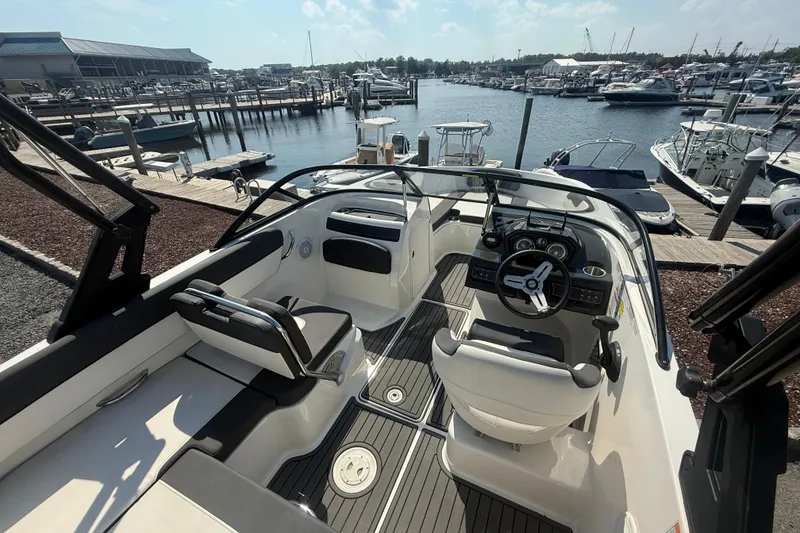 Slide: The Image of 2019 Bayliner VR5 Bowrider OB interior with steering wheel, docked at marina. - 6