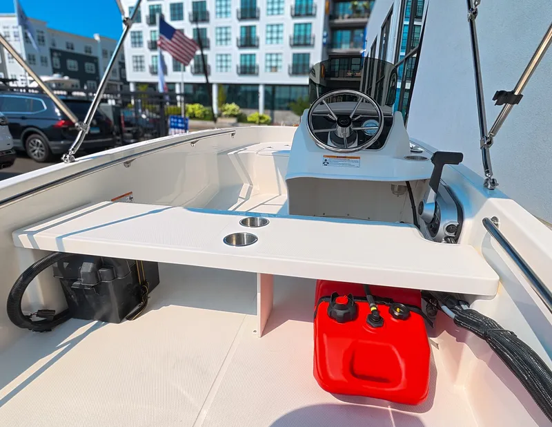 Slide: The Image of The image shows the cockpit of a 2027 Boston Whaler 130 Super Sport. It features a simple design with a steering wheel and a red fuel can. - 7