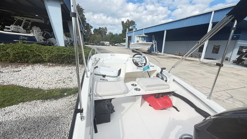 Slide: The Image of The image shows a 2027 Boston Whaler 130 Super Sport boat in a marina area with blue buildings in the background. - 4